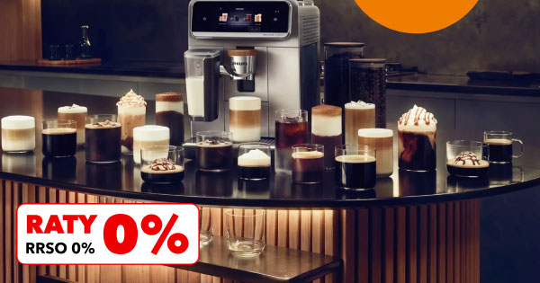 Na blacie znajduje się ekspres do kawy oraz różnorodne filiżanki i szklanki z różnymi rodzajami kawy, w tym z pianką i bitą śmietaną. W lewym dolnym rogu widnieje napis RATY 0%, RRSO 0%.